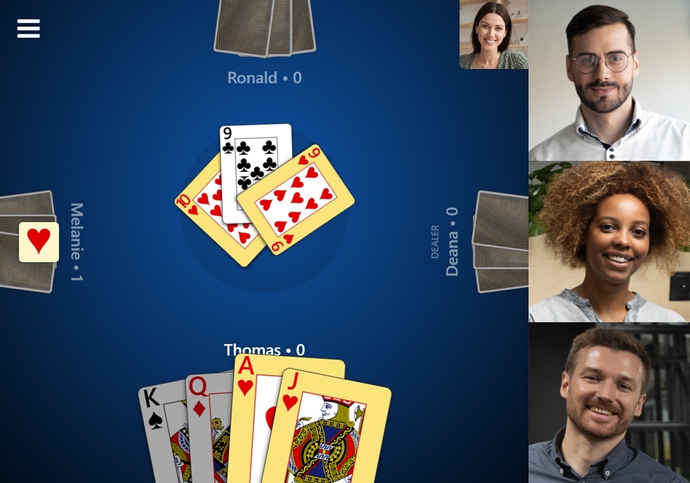 Screenshot of a game mid-trick in Trickster Euchre with video chat enabled. Three videos from other players' webcams are shown to the right.'